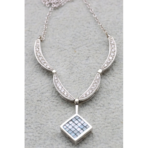 598 - An Indian 14ct white gold drop pendant mounted with square of small pale blue stones with further di... 