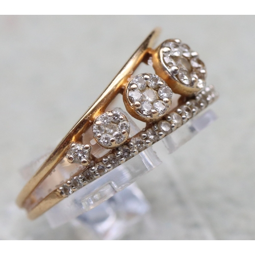 603 - An 18ct gold ring set with 4 graduated diamonds below a row of small diamonds, stamped 