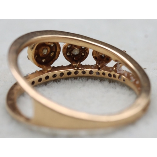 603 - An 18ct gold ring set with 4 graduated diamonds below a row of small diamonds, stamped 