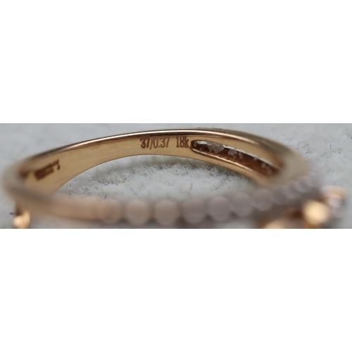 603 - An 18ct gold ring set with 4 graduated diamonds below a row of small diamonds, stamped 