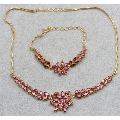 608 - An Indian 22ct gold drop necklace mounted with pink/purple stones, 39.5cm long and a matching bracel... 