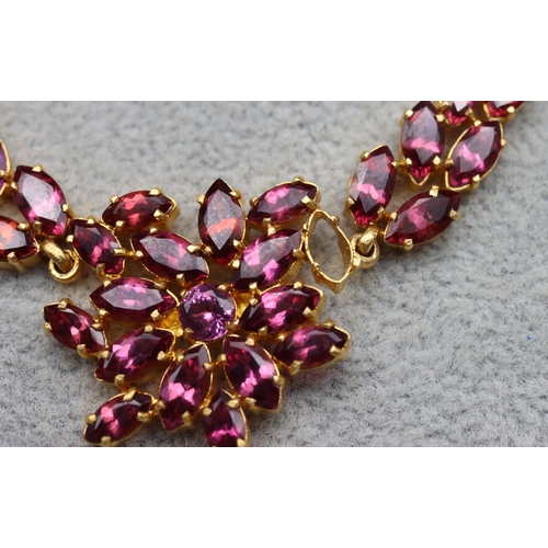 608 - An Indian 22ct gold drop necklace mounted with pink/purple stones, 39.5cm long and a matching bracel... 