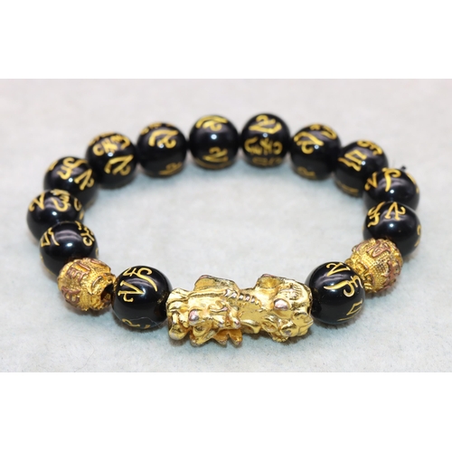 617 - An Oriental black bead expanding bracelet