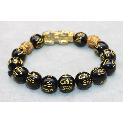 617 - An Oriental black bead expanding bracelet