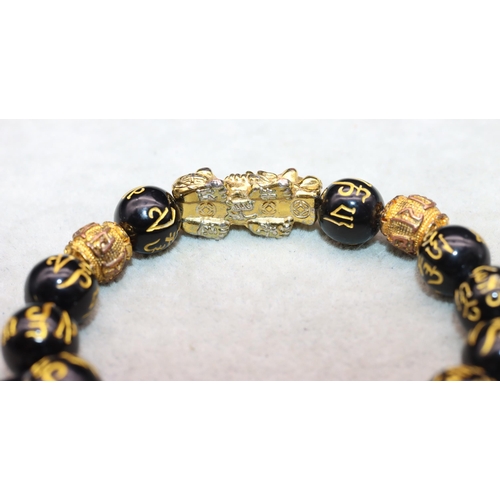 617 - An Oriental black bead expanding bracelet