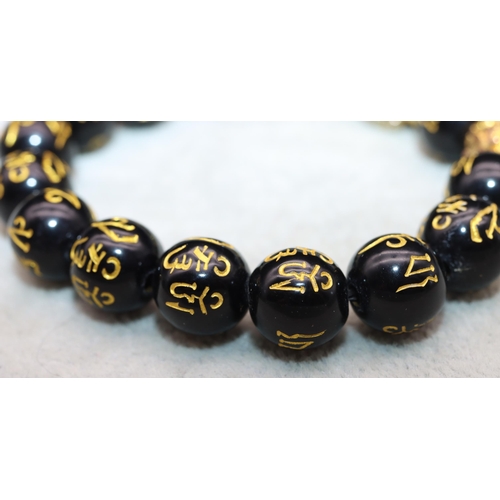 617 - An Oriental black bead expanding bracelet