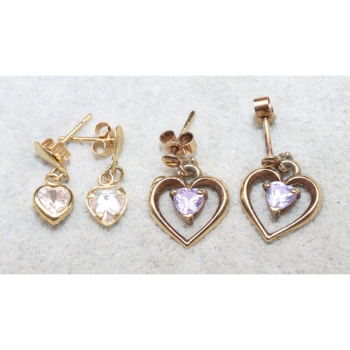 624 - A pair of small 9ct gold heart shaped earrings mounted with purple stones and another pair of gold e... 