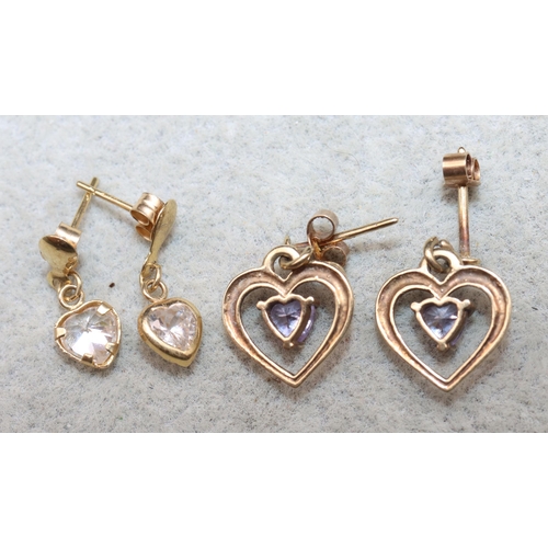 624 - A pair of small 9ct gold heart shaped earrings mounted with purple stones and another pair of gold e... 