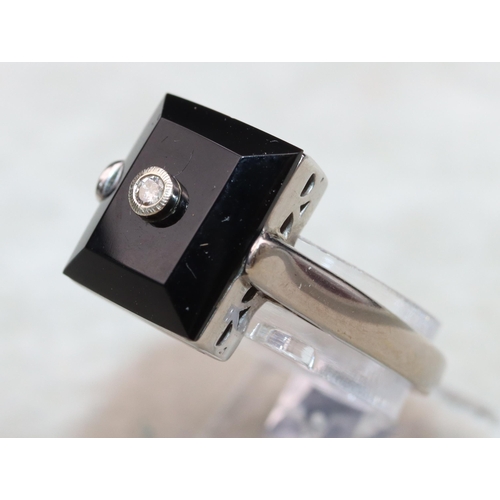 644 - A 9ct white gold ladies' rectangular shaped ring set with black stone inset with small diamonds, Siz... 