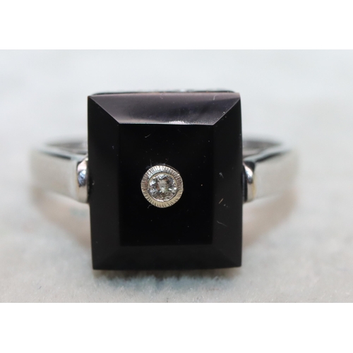 644 - A 9ct white gold ladies' rectangular shaped ring set with black stone inset with small diamonds, Siz... 