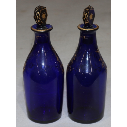 65 - A pair of Georgian Bristol blue glass small round bulbous thin necked spirit decanters with gilt dec... 