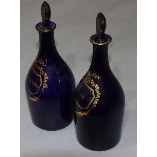 66 - A pair of Georgian round bulbous thin necked Bristol blue glass decanters with stoppers and gilt dec... 