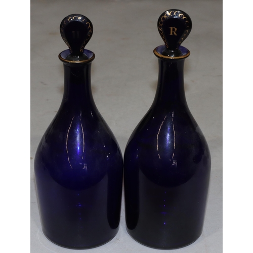 66 - A pair of Georgian round bulbous thin necked Bristol blue glass decanters with stoppers and gilt dec... 