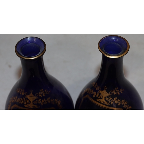 66 - A pair of Georgian round bulbous thin necked Bristol blue glass decanters with stoppers and gilt dec... 