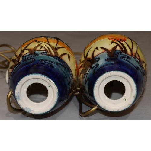 68 - A pair of modern Moorcroft round bulbous shaped table lamps with multi-coloured reeded decoration, 3... 