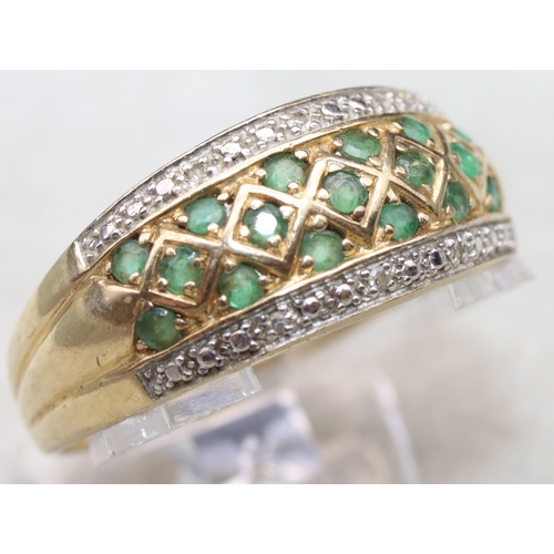 683 - A 14ct gold ladies' ring set with 17 green stones, flanked by 2 rows of small diamond chips, Size Y,... 