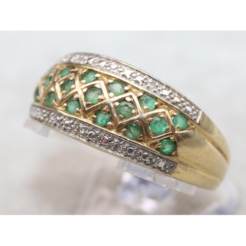 683 - A 14ct gold ladies' ring set with 17 green stones, flanked by 2 rows of small diamond chips, Size Y,... 