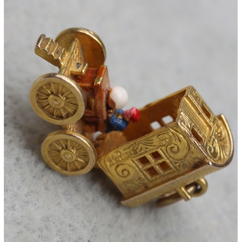 699 - A 9ct gold charm in the form of a Gypsy caravan with hinge top enclosing figure, 4 grams