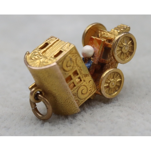 699 - A 9ct gold charm in the form of a Gypsy caravan with hinge top enclosing figure, 4 grams