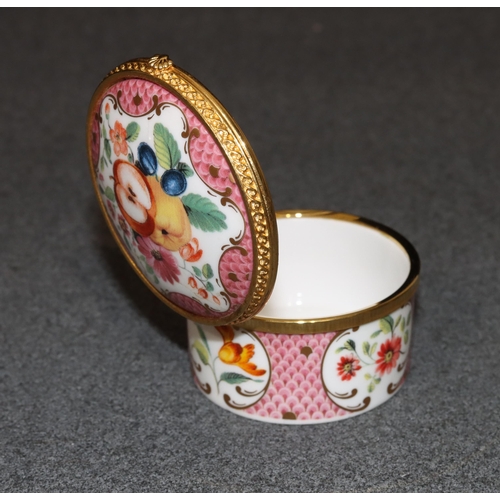 73 - A Royal Worcester Connoisseur Collection round pill box with hinged lid on white and pink ground wit... 