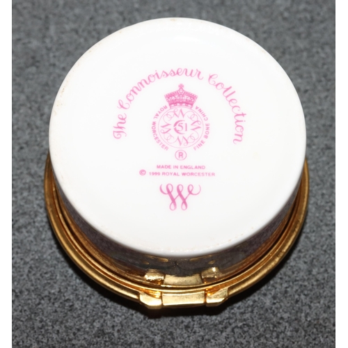 73 - A Royal Worcester Connoisseur Collection round pill box with hinged lid on white and pink ground wit... 