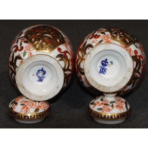 91 - A pair of Derby Imari pattern round bulbous lidded pots (1 finial missing), 13cm high