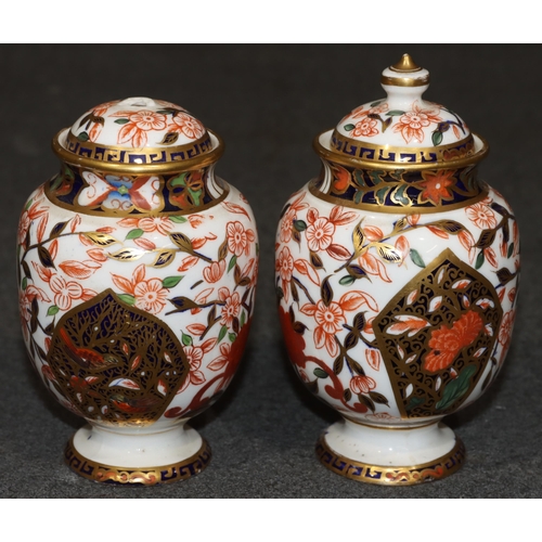 91 - A pair of Derby Imari pattern round bulbous lidded pots (1 finial missing), 13cm high