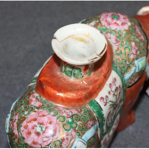 107 - A pair of Chinese candlesticks in the form of elephants on red ground with Cantonese style decoratio... 