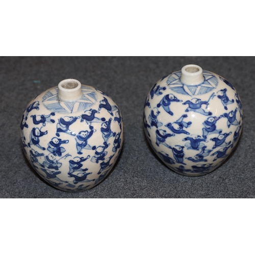 111 - A pair of Chinese miniature round bulbous thin necked vases on blue and white ground with allover fi... 