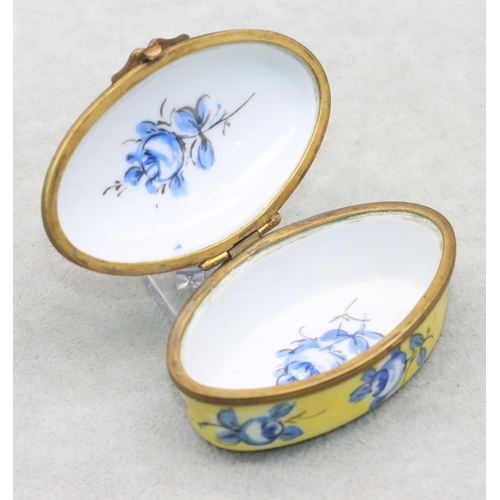 125 - A Sevres oval snuff box on yellow and blue ground with floral and leaf decoration, 7.7cm wide