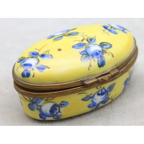 125 - A Sevres oval snuff box on yellow and blue ground with floral and leaf decoration, 7.7cm wide