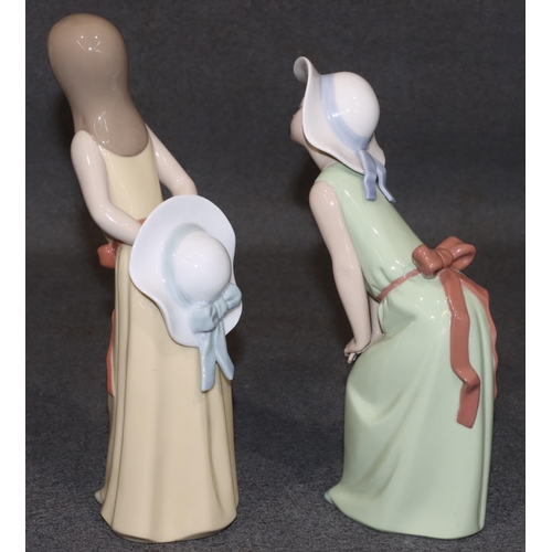 127 - 2 Lladro figures of standing young ladies holding hats in yellow and green dresses, largest 24cm hig... 