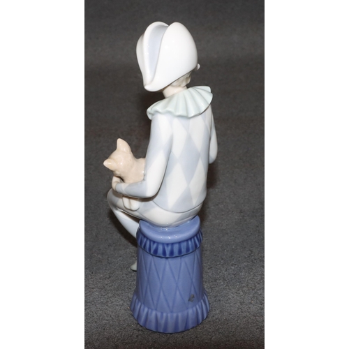 131 - A Lladro figure of a seated young boy dressed as a jester holding a cat, 23cm high