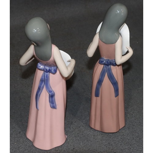 132 - 2 Lladro figures of standing young ladies holding hats, wearing pink dresses, largest 25.5cm high (2... 