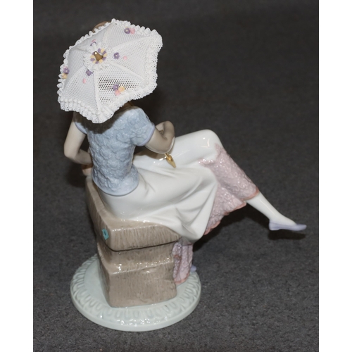 139 - A Lladro figure of a young seated lady with dog and parasol (parasol loose), 21cm high (boxed)