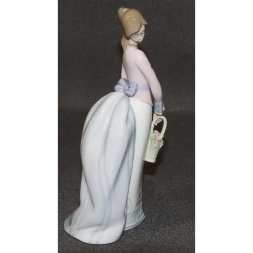 140 - A Lladro figure of a standing young lady holding a basket of encrusted flowers, 24.5cm high (boxed)