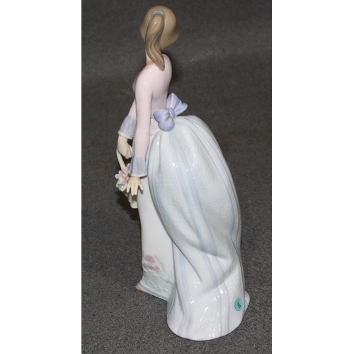 140 - A Lladro figure of a standing young lady holding a basket of encrusted flowers, 24.5cm high (boxed)