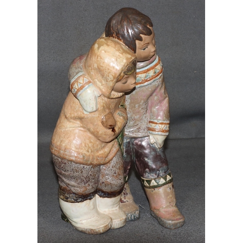 150 - A Lladro large glazed earthenware group of Eskimos cuddling, 38cm high