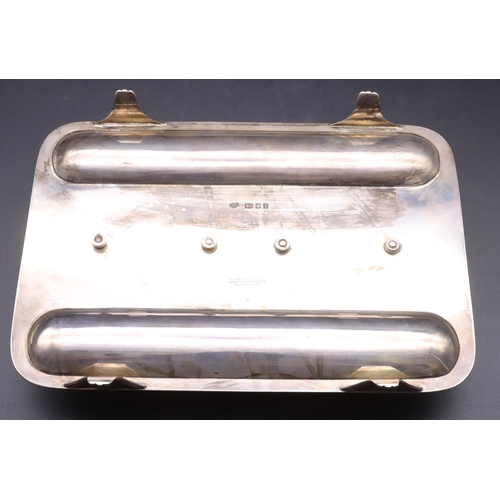 399 - A George V silver rectangular shaped inkwell with 2 oval lidded oval inkwells enclosing glass liners... 