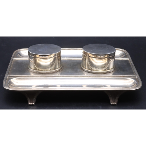 399 - A George V silver rectangular shaped inkwell with 2 oval lidded oval inkwells enclosing glass liners... 