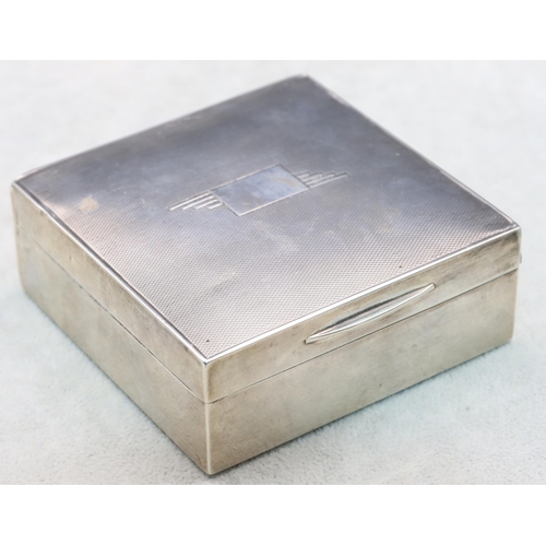 402 - A London silver square cigarette box with engine turned hinged lid enclosing a cedar lined interior,... 