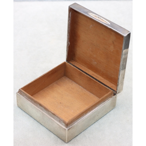 402 - A London silver square cigarette box with engine turned hinged lid enclosing a cedar lined interior,... 