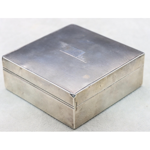 402 - A London silver square cigarette box with engine turned hinged lid enclosing a cedar lined interior,... 