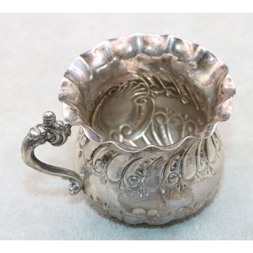 404 - A Victorian Birmingham silver small bulbous shaped cream jug with crinkled rim, scroll handle and em... 