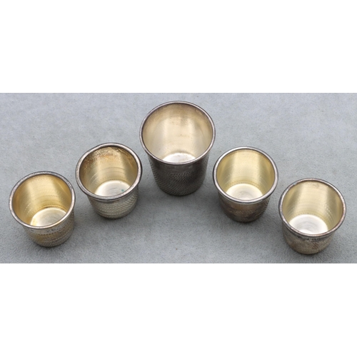 406 - A set of 4 silver plated shot glasses in the form of thimbles and a similar larger thimble (5)