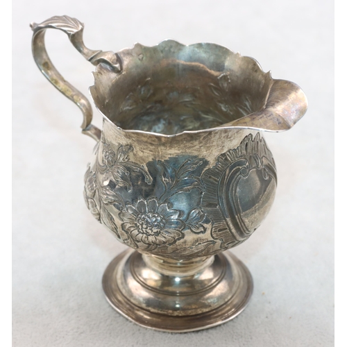 412 - A George III round bulbous shaped cream jug with crinkle rim and scroll handle with embossed floral ... 