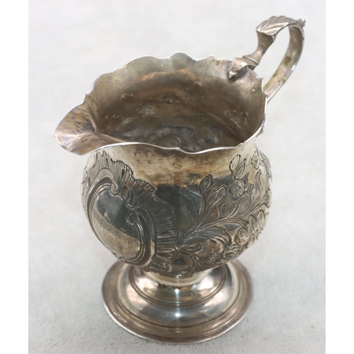 412 - A George III round bulbous shaped cream jug with crinkle rim and scroll handle with embossed floral ... 