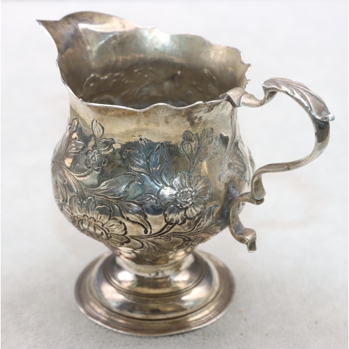 412 - A George III round bulbous shaped cream jug with crinkle rim and scroll handle with embossed floral ... 