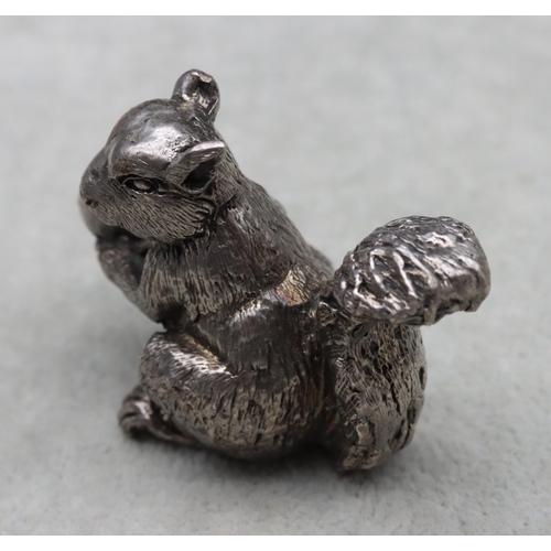 422 - A cast silver model of a squirrel holding a half-eaten nut, 4cm high,3.1oz