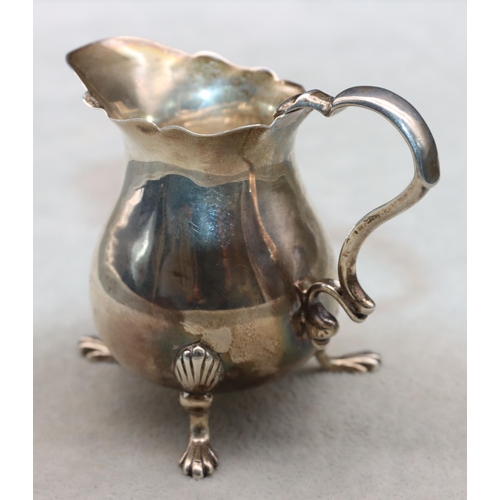 423 - A small Victorian silver cream jug with crinkle rim and scroll handle on splayed feet, 6.5cm high, 1... 